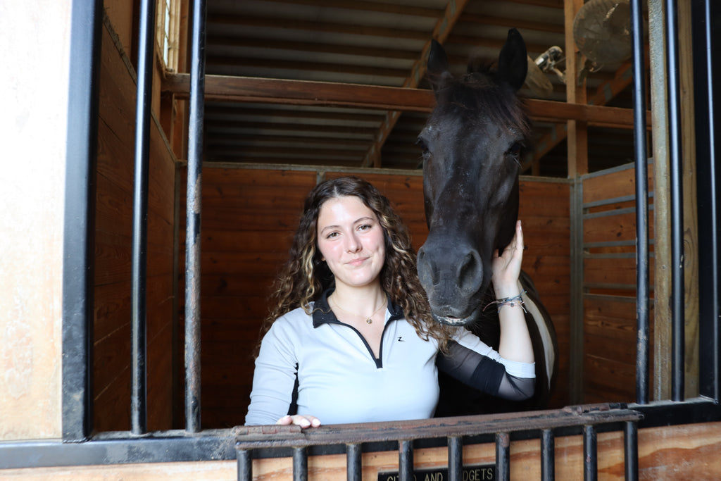 girl smiles with horse wearing gold necklace