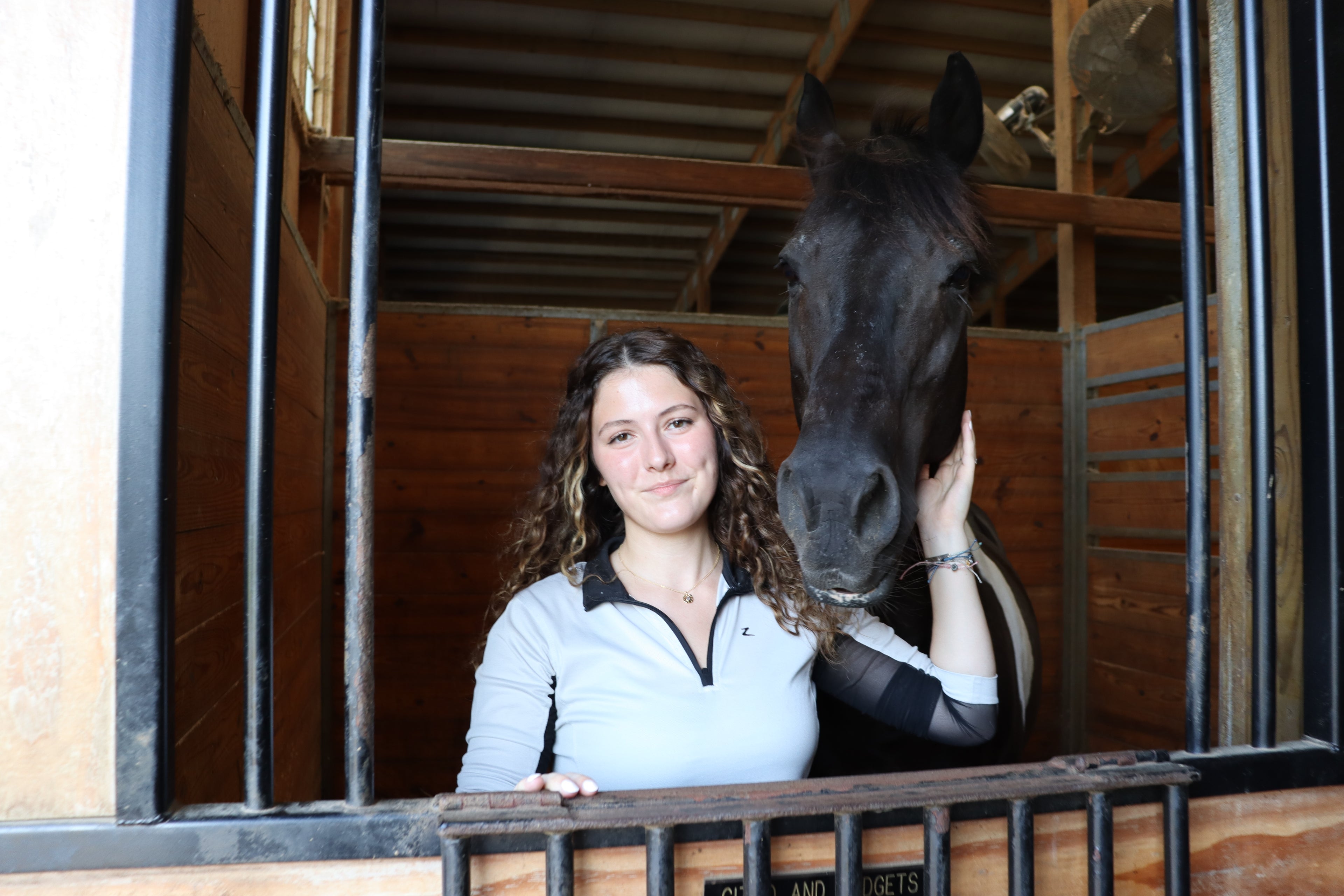 girl smiles with horse wearing gold necklace
