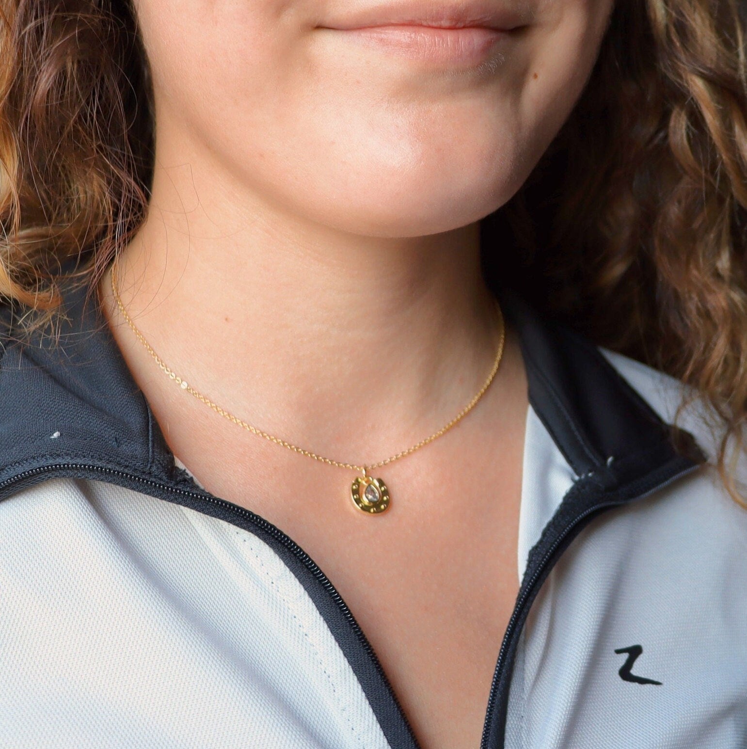 horse shoe  necklace on girl's neck
