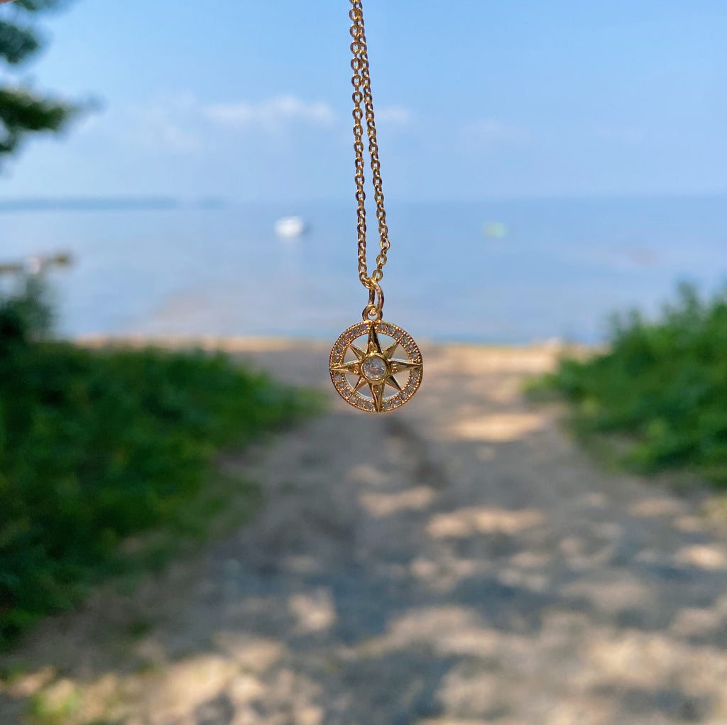 compass necklace with beach background