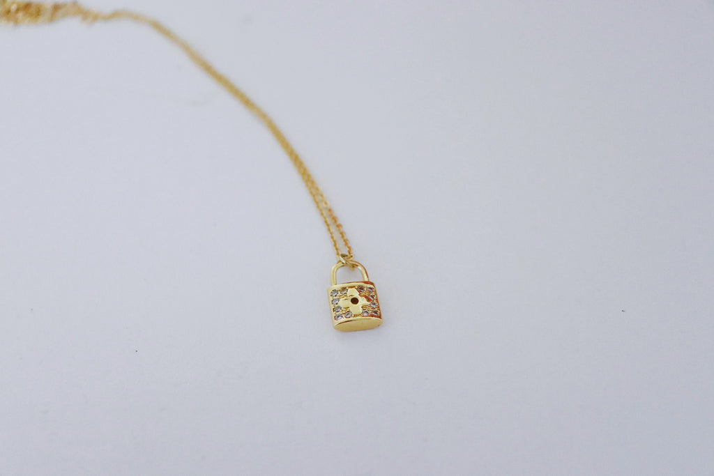 gold lock necklace on white background
