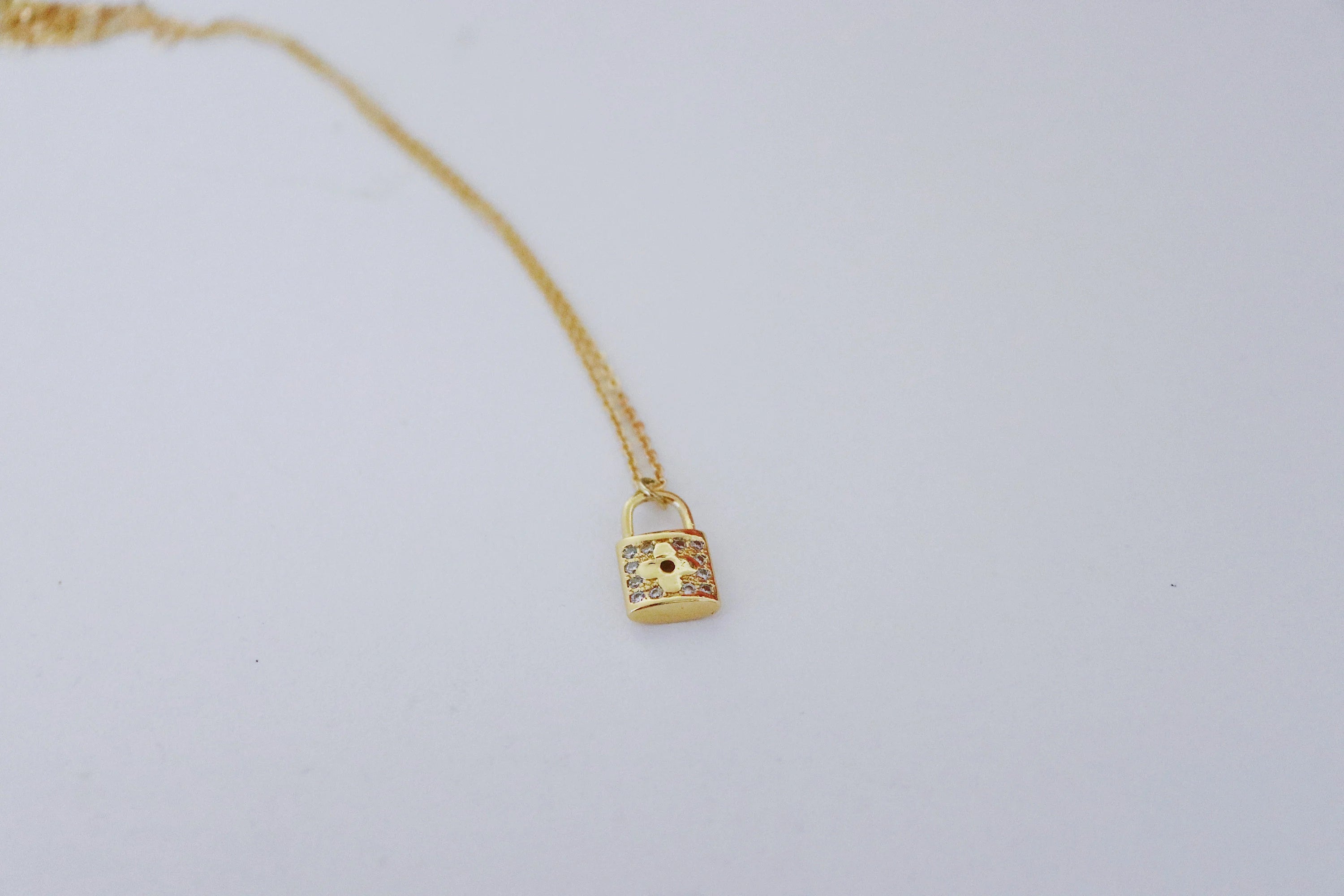 gold lock necklace on white background
